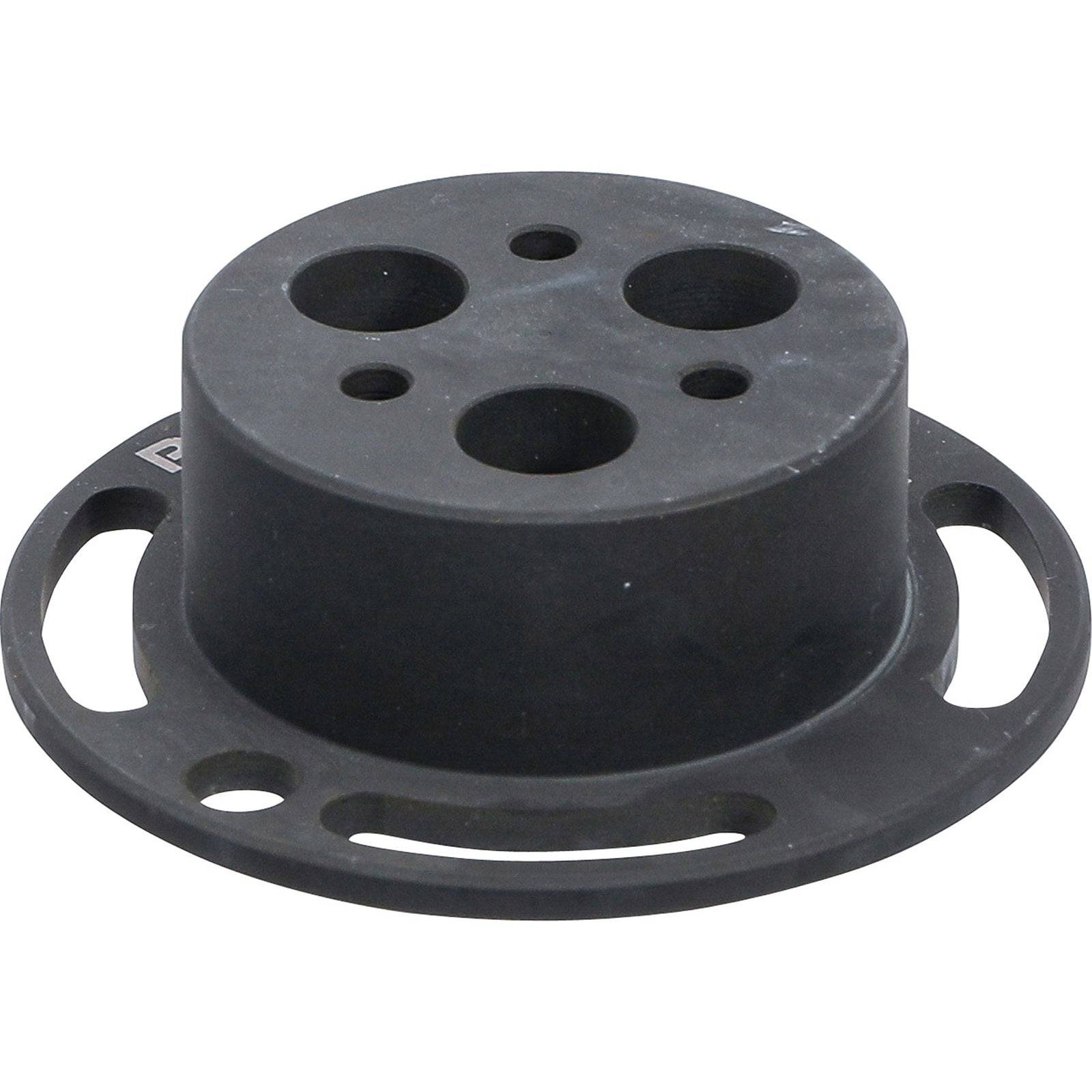 Eine kreisförmige schwarze Kunststoffkomponente mit mehreren Löchern, möglicherweise ein Verbinder oder Montageteil, aus einem Blickwinkel betrachtet.