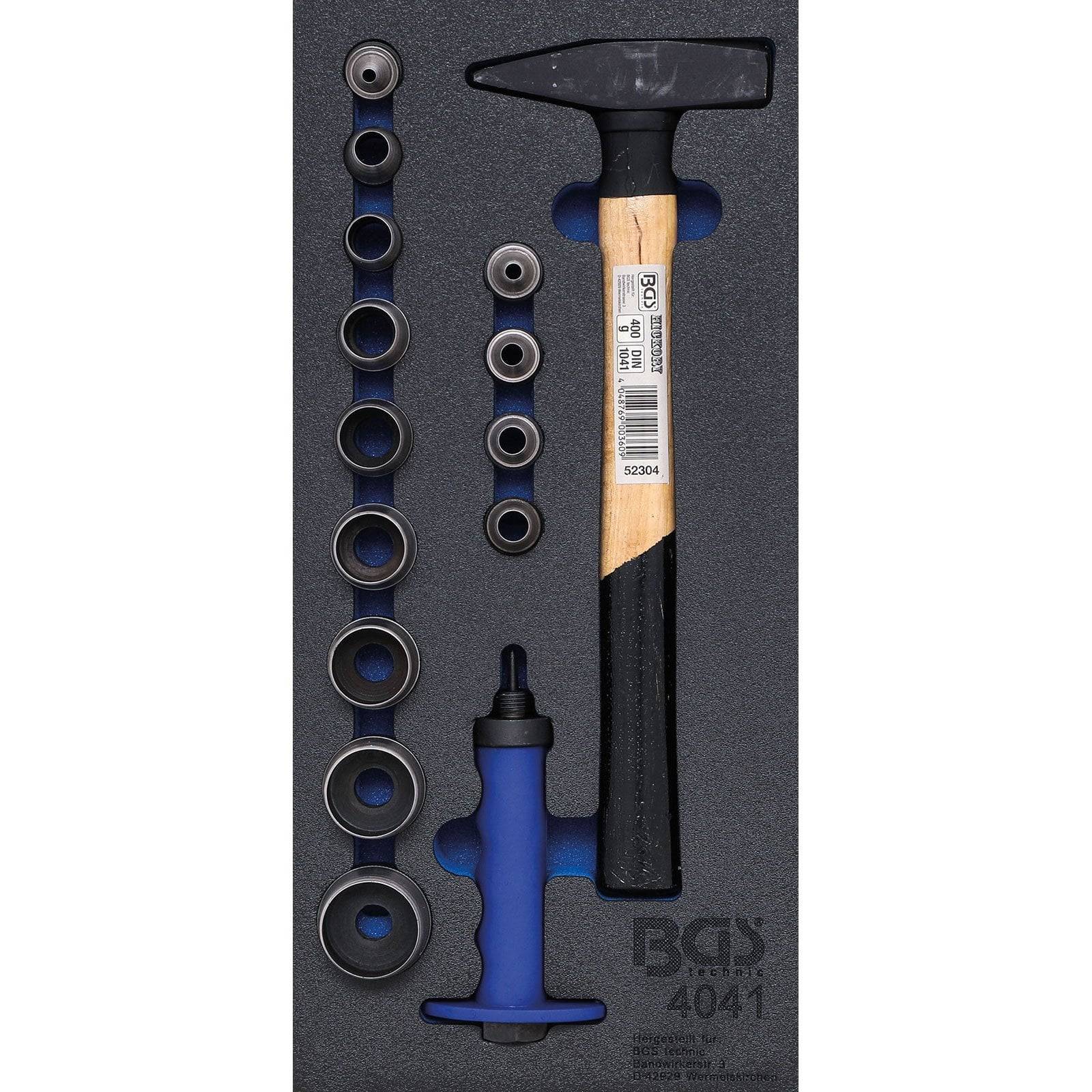 Ein Hammer mit einem Holzgriff und verschiedenen Metallringen und -komponenten, die ordentlich in einer Schaumstoffeinlage angeordnet sind, als Teil eines Werkzeugkastens.