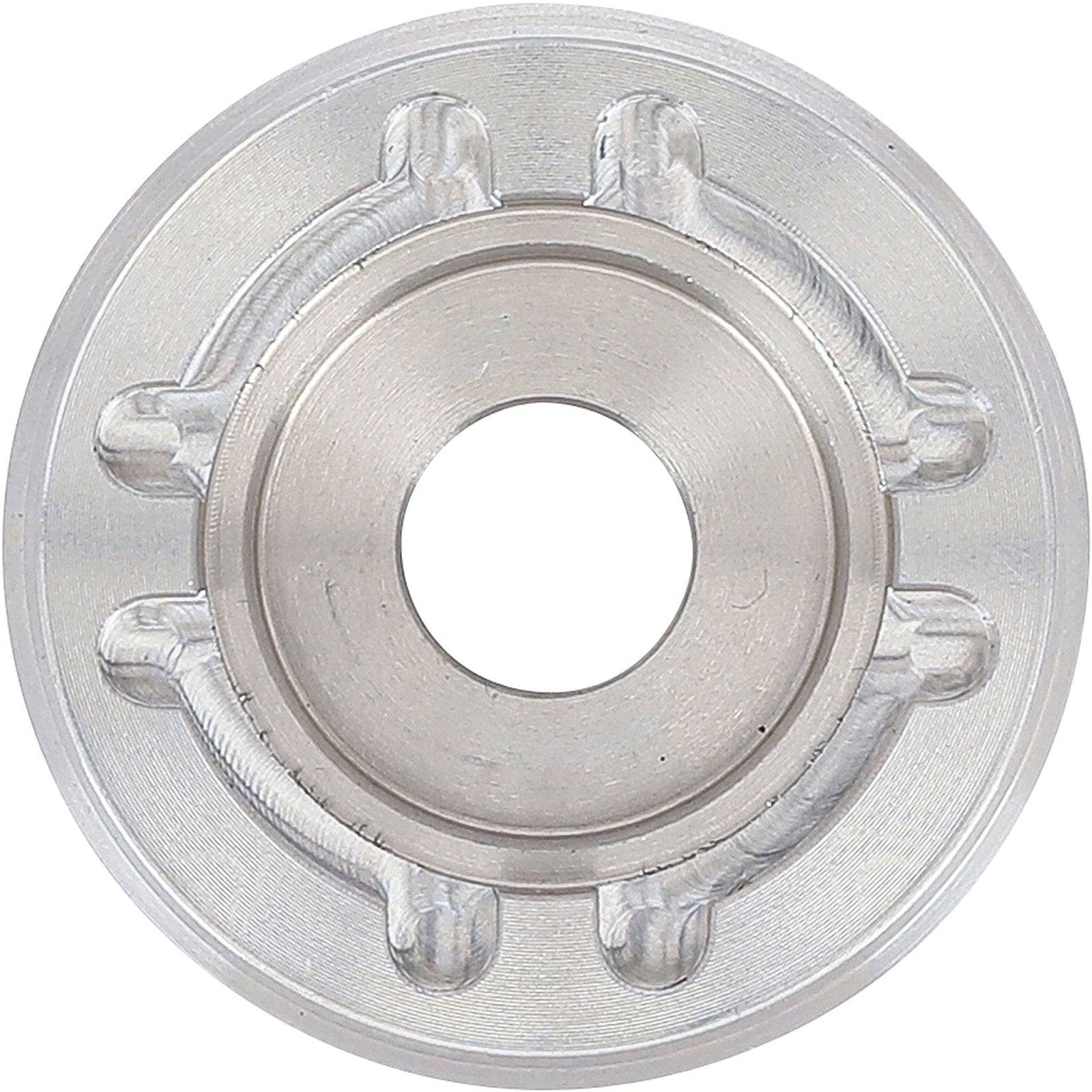 Eine Nahaufnahme eines runden, metallischen mechanischen Bauteils mit einer zentralen Öffnung und zahnradähnlichen Vorsprüngen entlang des inneren Randes.