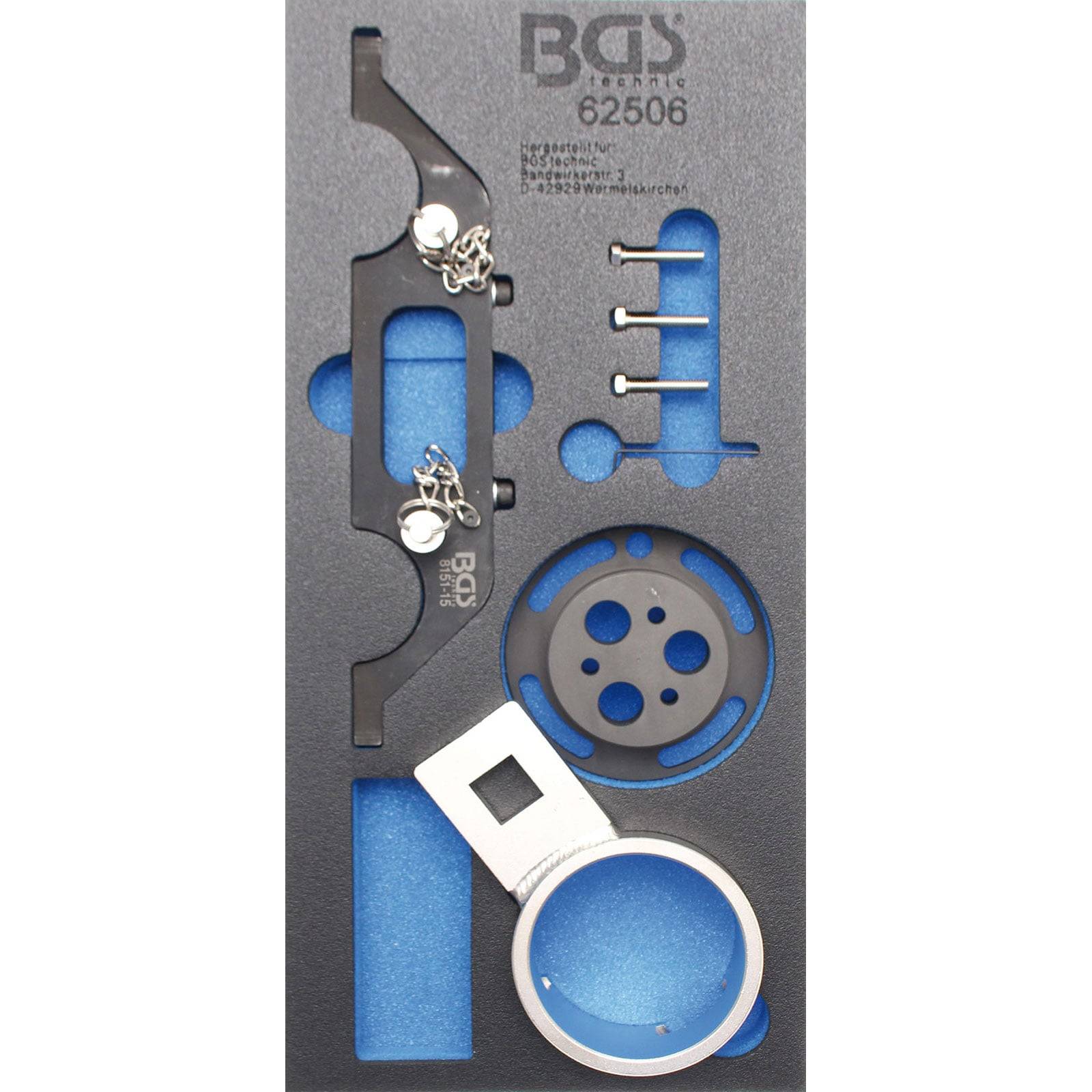 Ein Satz Fahrzeug-Timingwerkzeuge in einem Schaumstoffeinsatz, bestehend aus einem Metallhalter, einer runden Scheibe, einem weißen quadratischen Werkzeug, vier Stifte und Schrauben.