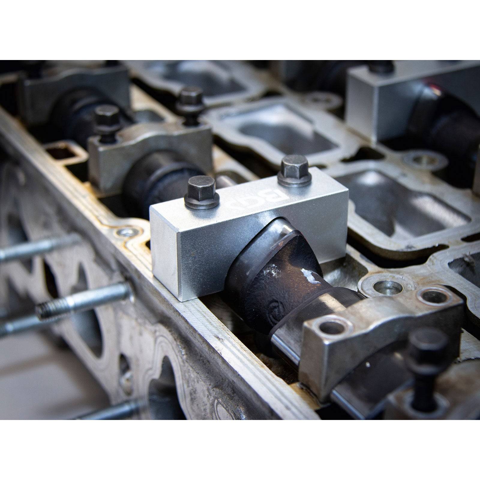 Nahaufnahme einer mechanischen Motorkomponente mit Metallgehäuse und Nockenwellenteilen, die eine detaillierte Maschinenassemblage veranschaulicht.