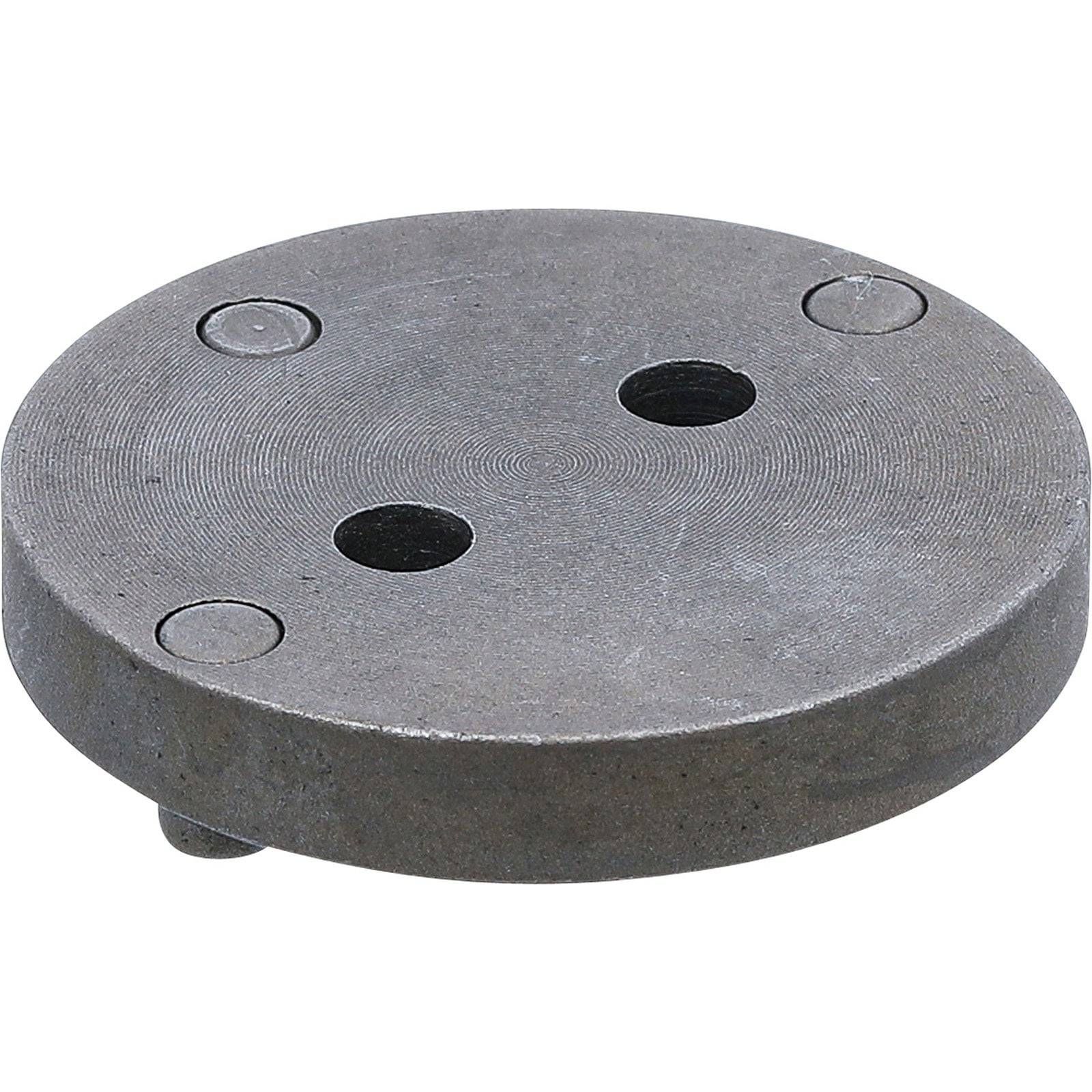 Ein rundes, flaches Metallinstrument mit drei kleinen Löchern auf der Oberseite, wahrscheinlich für spezifische mechanische oder industrielle Anwendungen verwendet.