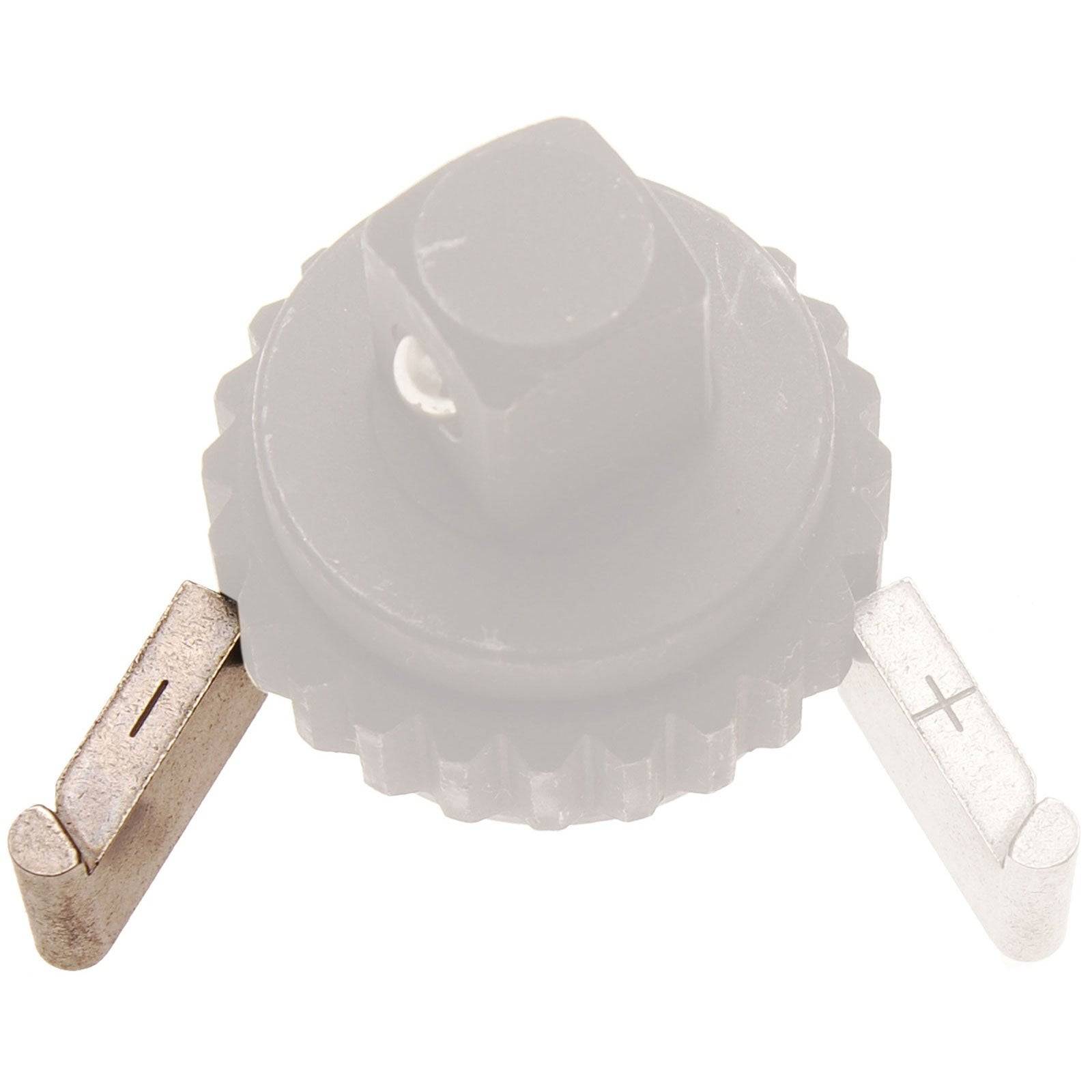 Eine kleine, kreisförmige elektrische Komponente mit einer nummerierten Skala und zwei Stiften, die mit Plus- und Minuszeichen gekennzeichnet sind und die Polarität anzeigen.