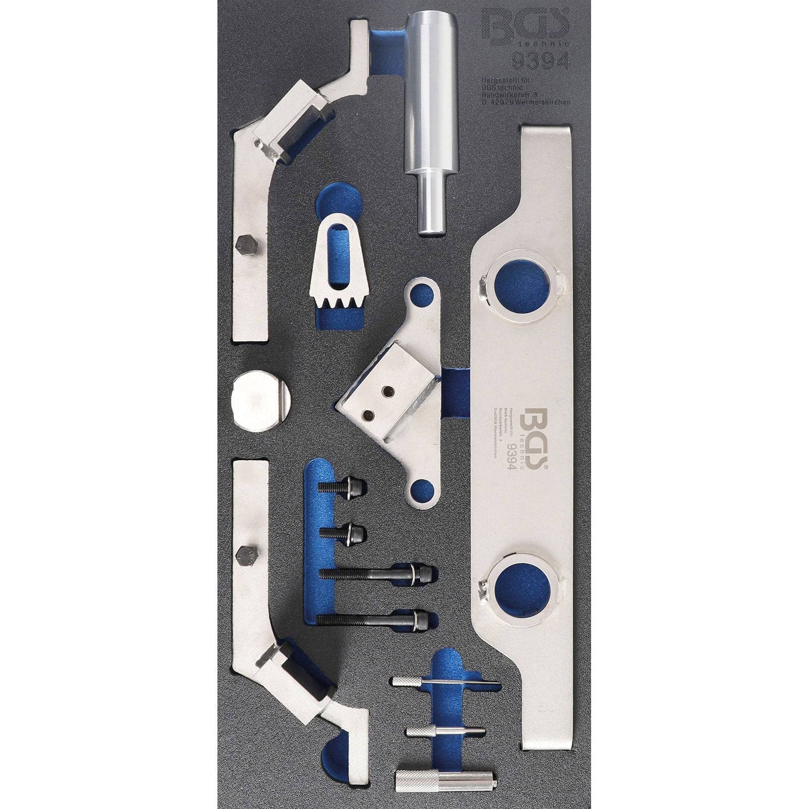 Eine Werkzeugsammlung mit verschiedenen metallischen Werkzeugen, sorgfältig in einer Schaumstoffplatte angeordnet, entwickelt für Präzisionsarbeiten. Die Werkzeuge umfassen Halterungen, Stifte und ein zylindrisches Stück.