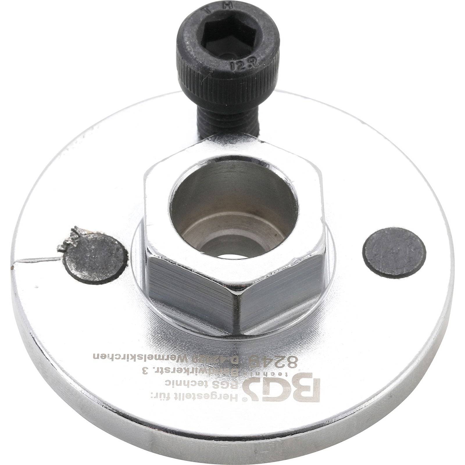 Eine Metallflansche mit einem zentralen Gewindeloch und zwei Seitenlöchern, möglicherweise zum Befestigen, mit einer Schraube, die in das obere Loch eingesetzt ist.