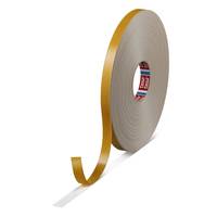 Rolle mit goldenem Klebeband mit einem lockeren Streifen, der sich von der Spule abrollt, auf weißem Hintergrund.