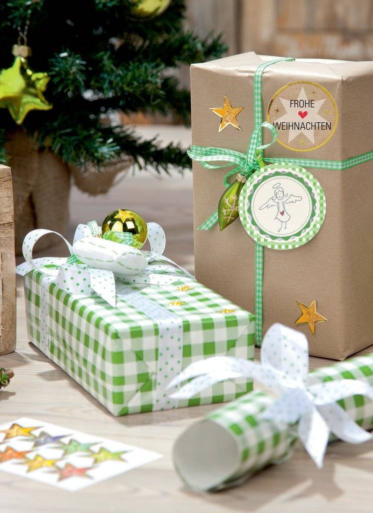 Eingewickelte Weihnachtsgeschenke auf einem Tisch, darunter eine hohe Kraftpapierbox mit der Aufschrift 