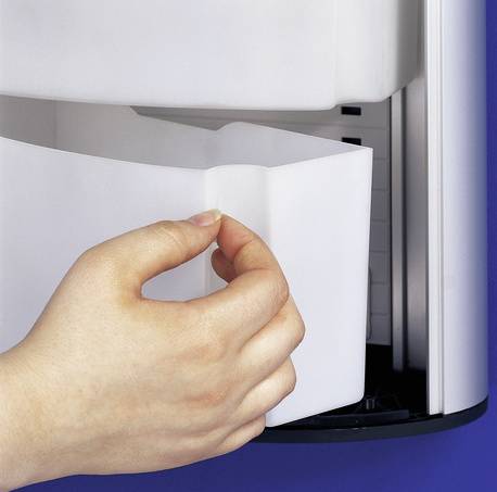 Hand, die Papier in eine Büropapierausgabe oder eine Schredder-Öffnung einführt.
