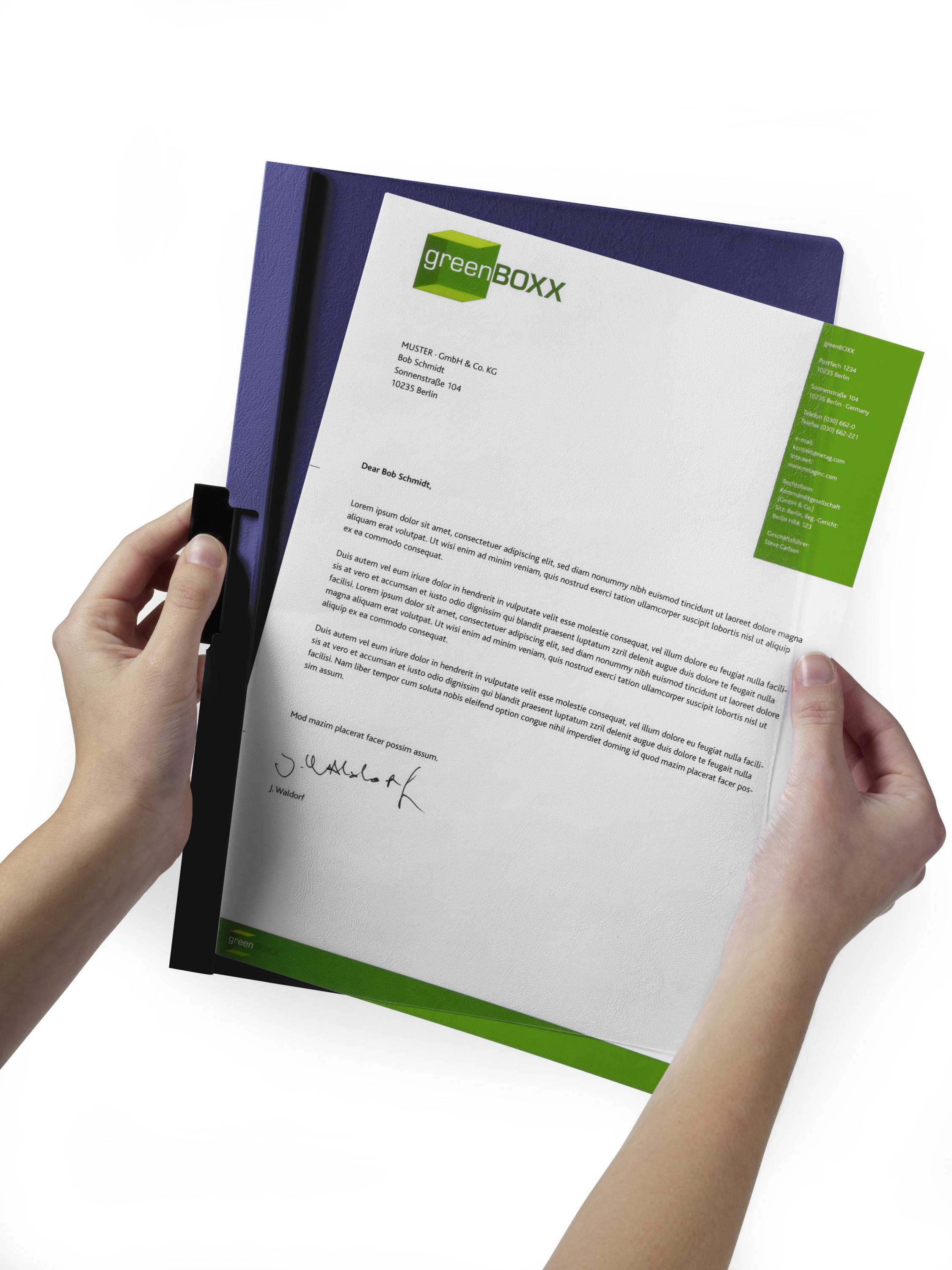 Hände, die einen mit greenBoxx gekennzeichneten Brief auf einem violetten Ordner halten, zeigen ein formelles Geschäftsdokument mit einer Unterschrift.