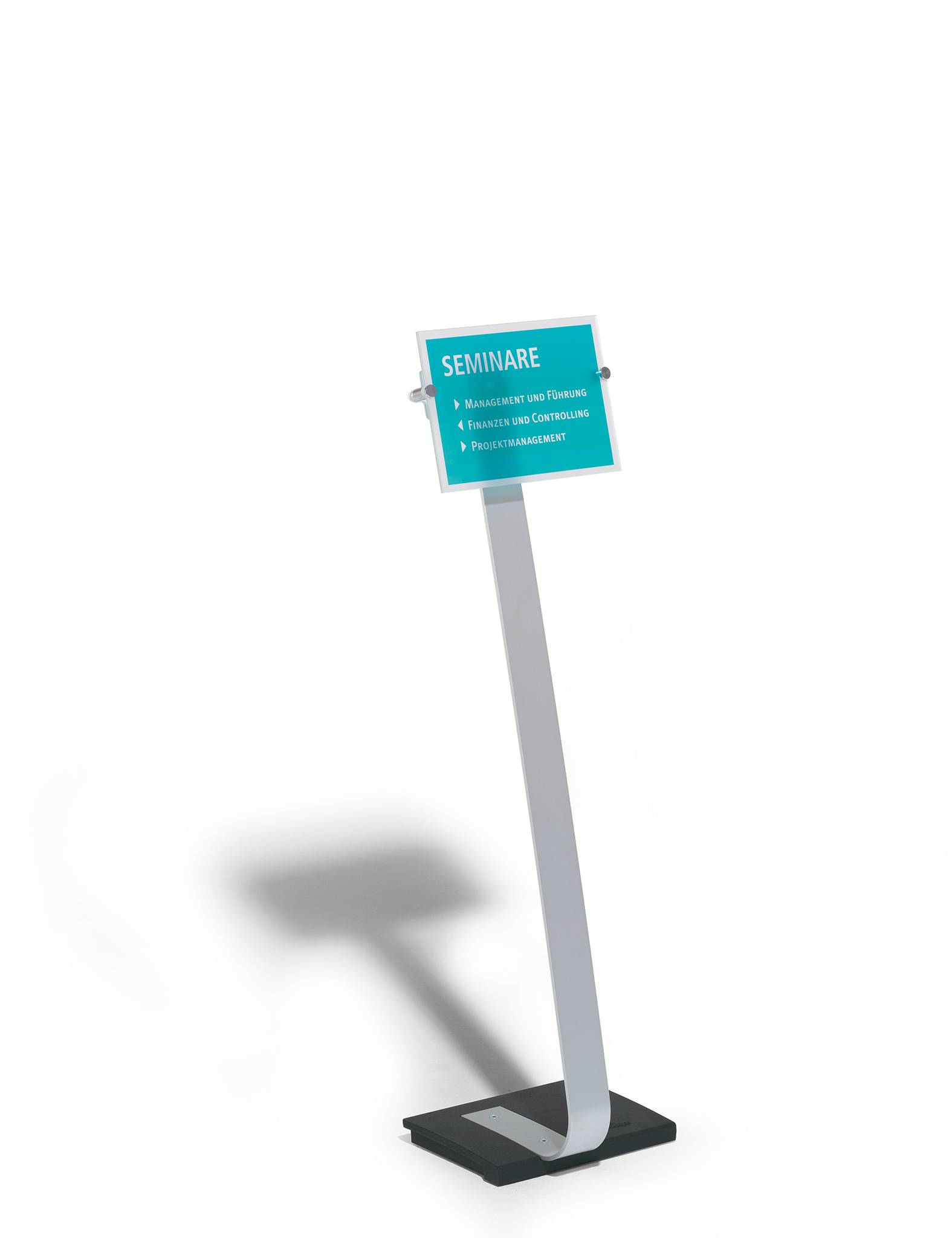 Ein schräg gestelltes Schild auf schwarzem Hintergrund zeigt: 'Seminare' mit folgenden Themen darunter: 'Management und Führung', 'Recht und Verwaltung', 'Projektmanagement'.