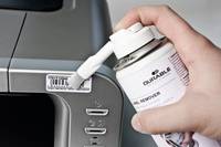 Eine Hand, die eine Spraydose mit Reiniger hält und diese in einen Computer- oder Monitor-Lüftungsschlitz und Anschlussöffnungen sprüht.