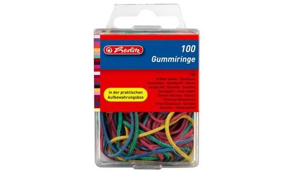 Verpackte Herlitz-'Gummiringe'-Gummibänder, 100er-Packung, in einer transparenten Kunststoffaufbewahrungsbox mit farbenfrohen Bändern, die innen sichtbar sind.