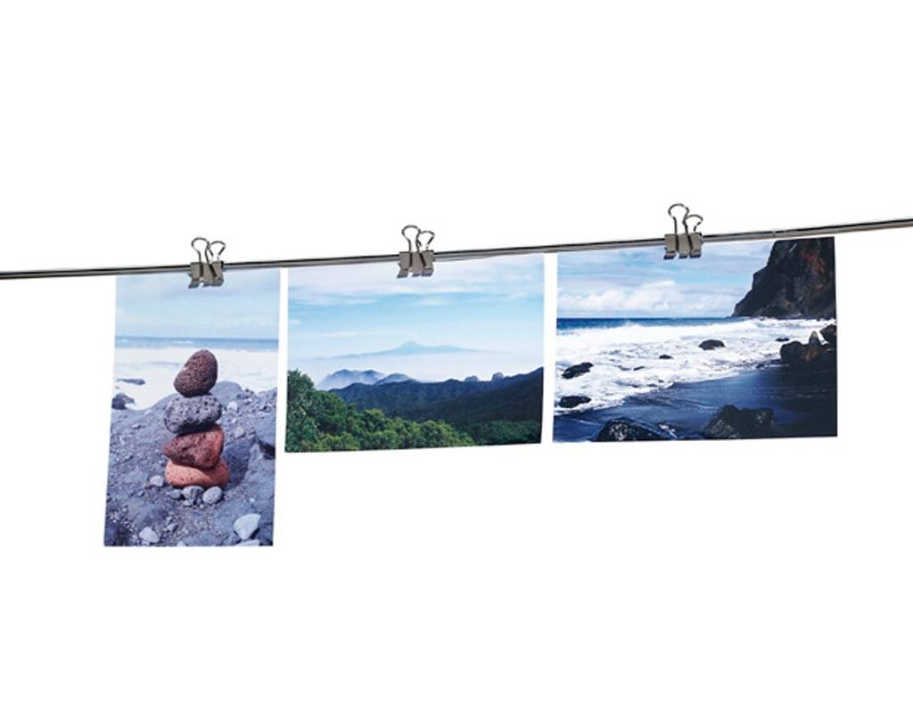 Drei Fotos an einer Schnur befestigt: aufgestapelte Steine an einem felsigen Strand, grüne Berge unter einem blauen Himmel und Wellen, die gegen eine Klippe krachen.