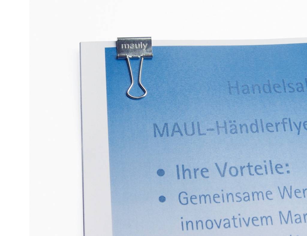 Nahaufnahme eines blauen Flugblatts, das mit einer silbernen Binder-Klammer mit der Aufschrift „mauly