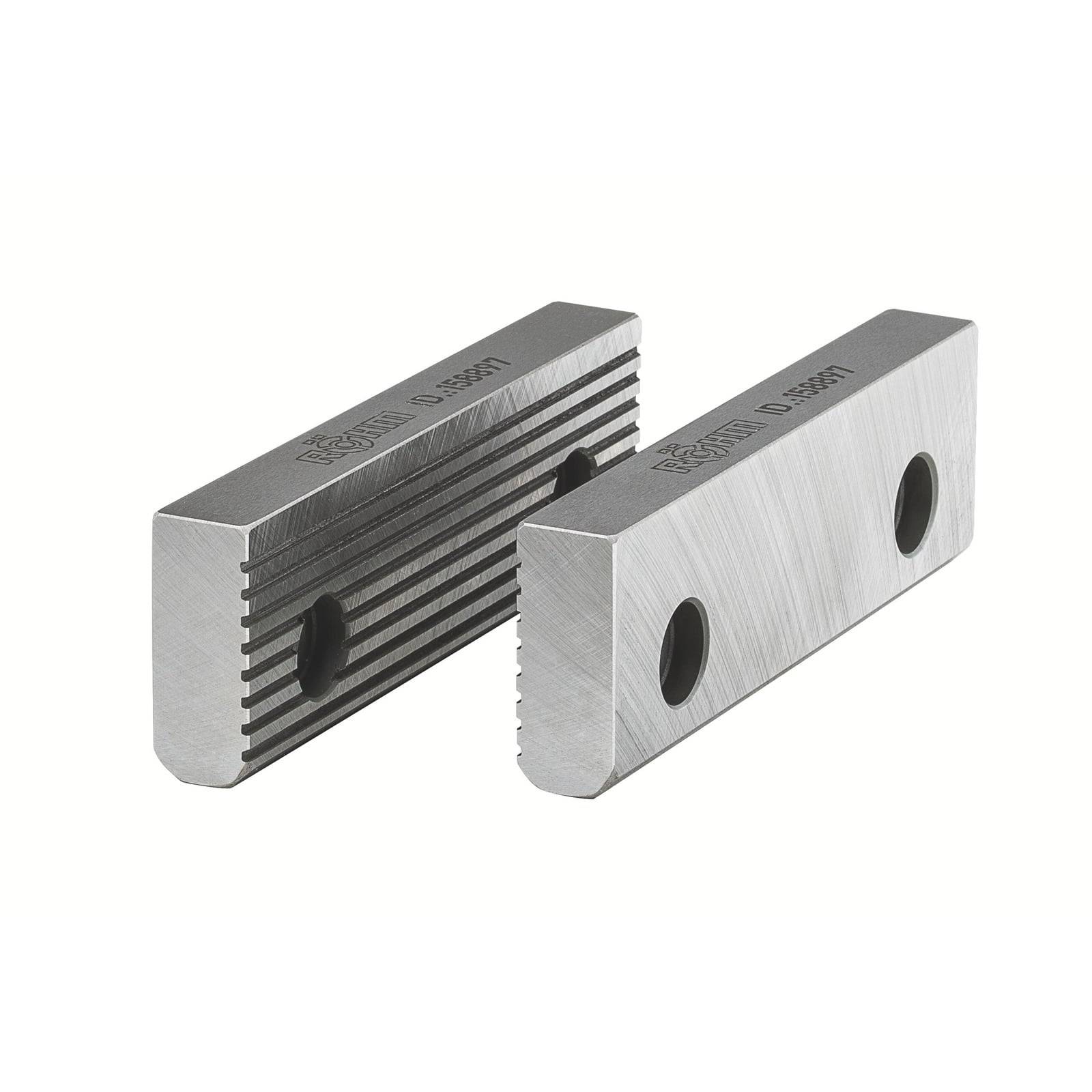 Zwei silberne rechteckige Metallblöcke mit strukturierten Oberflächen, die kreisförmige Löcher aufweisen und in leicht unterschiedlichen Winkeln positioniert sind.