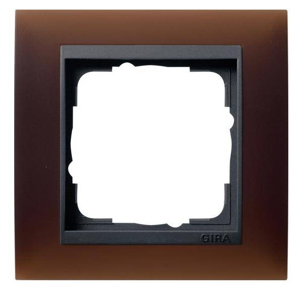 Ein quadratischer braun-schwarzer Kunststoffrahmen mit leerer Mitte, wahrscheinlich zum Anbringen einer Schalter- oder Steckdosenabdeckung. Die Marke 