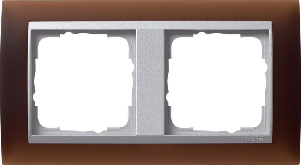 Eine braune Wand zeigt eine doppelte Steckdose mit zwei leeren weißen Schlitzen für Stecker, die in einem metallischen Rahmen angebracht ist.