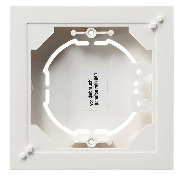 Ein quadratischer, weißer Kunststoffrahmen für elektrische Installationen mit kreisförmiger Öffnung und Montagelöchern.