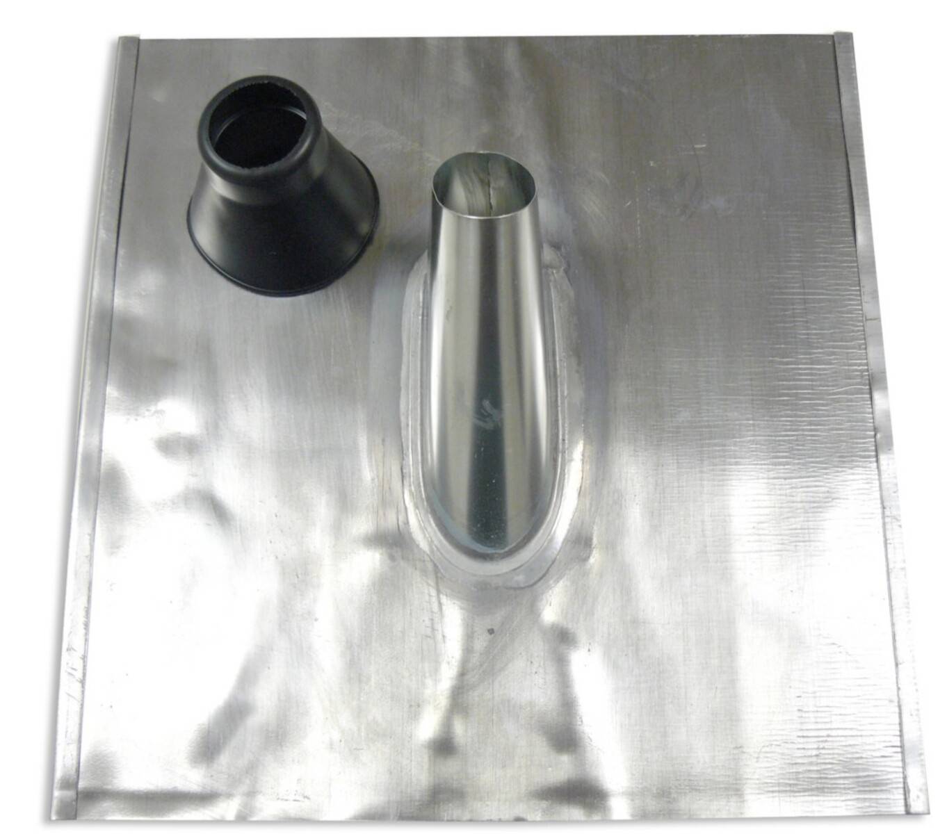 Eine Metalldacheindeckung mit einem hervorstehenden Entlüftungsrohr und einem schwarzen Gummistiefel auf einer folienumwickelten quadratischen Basis, verwendet zum Abdichten von Dachrohrübergängen.