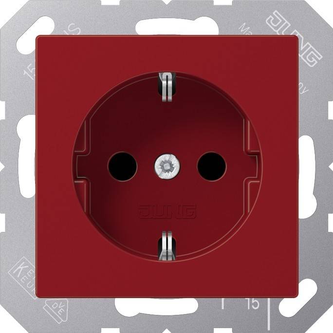 Eine rote elektrische Wandsteckdose mit zwei Stiften und einem Erdungsloch in der Mitte, die für europäische Steckertypen ausgelegt ist.