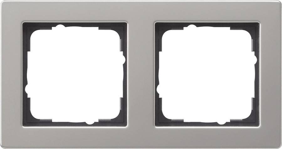 Zwei leere rechteckige Aussparungen in einem grauen Rahmen, möglicherweise für elektrische Schalter oder Steckdosen, vor einem einfarbigen Hintergrund abgebildet.