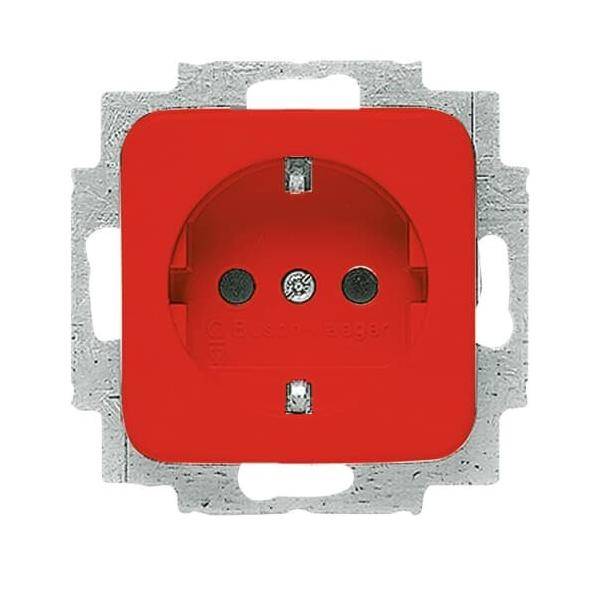 Eine rote elektrische Steckdose mit zwei Steckplätzen und einem Erdungsstift, montiert auf einem Metallrahmen, für Wandmontage konzipiert.
