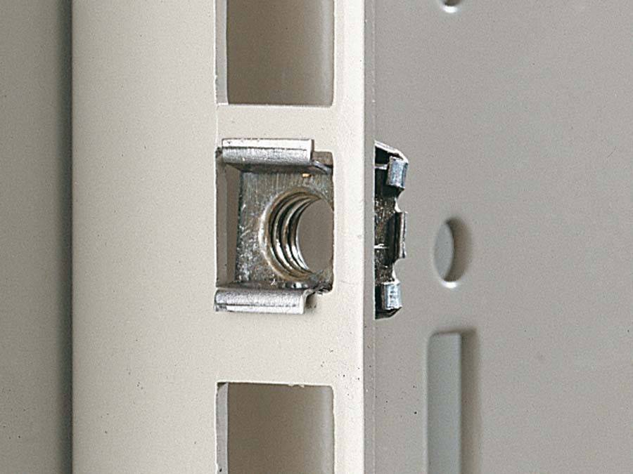 Nahaufnahme eines Metallhalters oder einer Halterung in einer Nut auf einer beigen Oberfläche, der wahrscheinlich zum Montieren oder Befestigen eines Objekts verwendet wird.