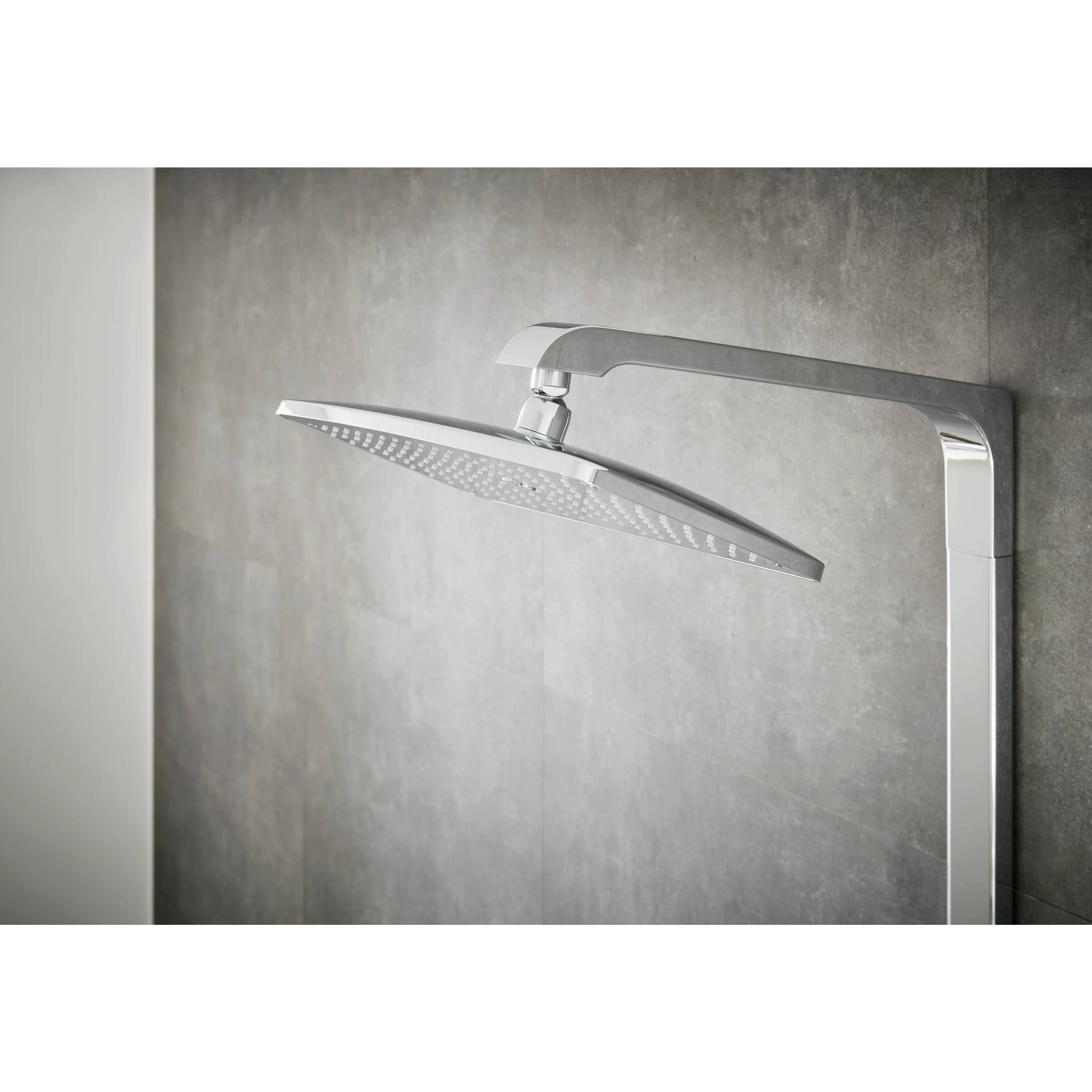 Moderner Duschkopf aus Chrom mit Regenfalleffekt auf einem gebogenen Arm, angebracht an einer grauen gefliesten Badezimmerwand.