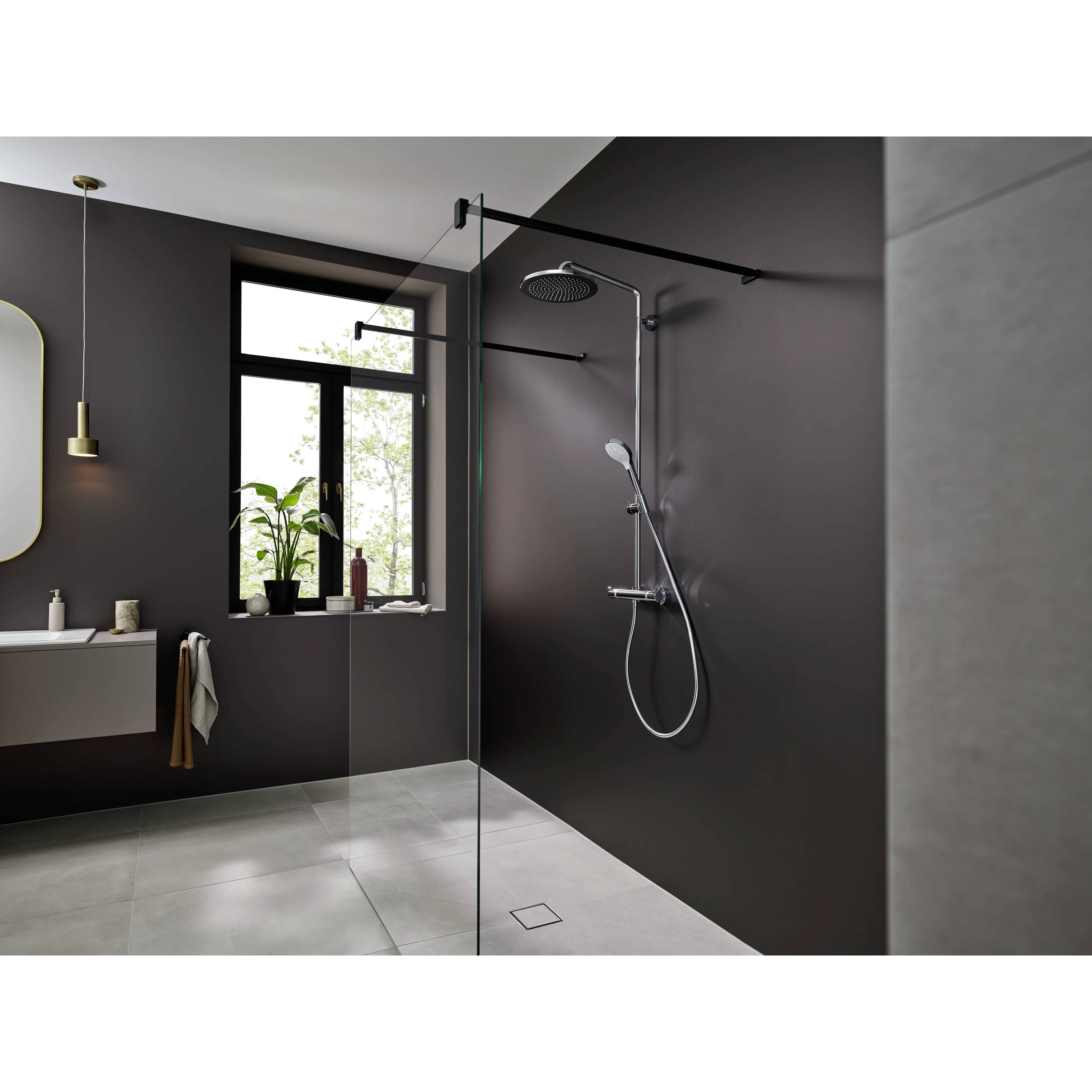 Modernes Badezimmer mit gläserner Duschkabine, wandmontierter Dusche, dunklen Akzentwänden, schwebendem Waschtisch, Fenster und hellgrauem Fliesenboden.
