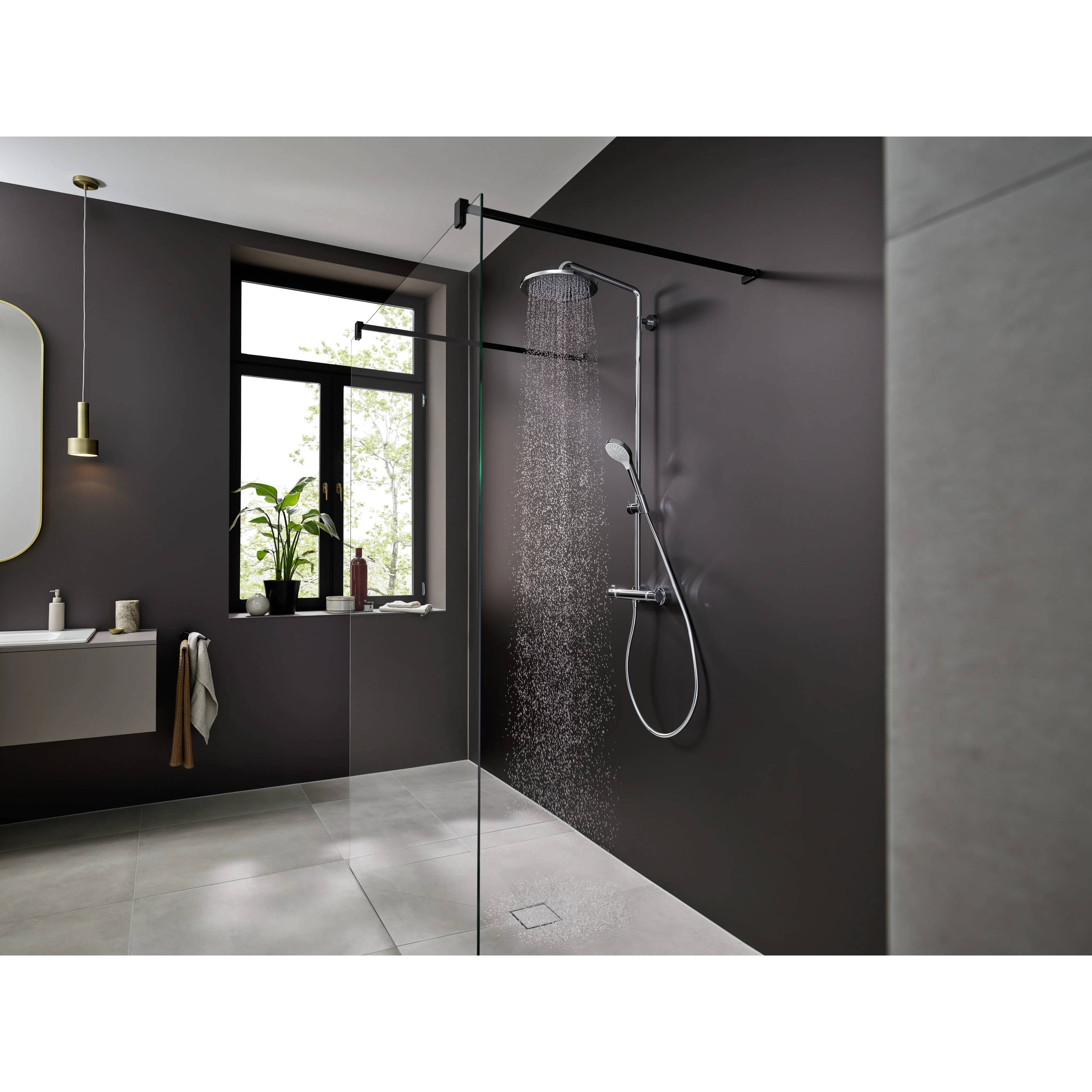 Modernes Badezimmer mit einer verglasten, laufenden Dusche, dunklen Wänden, Fenster, Waschtisch und großen grauen Bodenfliesen.