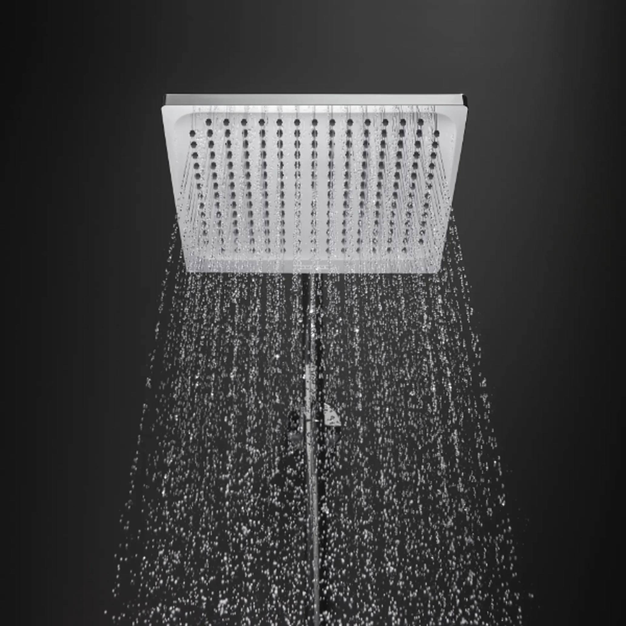 Quadratischer, an der Decke montierter Duschkopf, der Wasser gerade nach unten gegen einen dunklen Hintergrund sprüht.