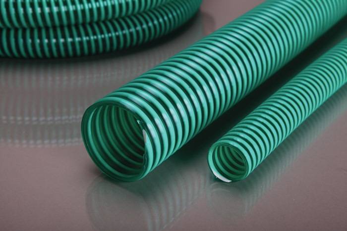 Grüne Schlauchsektionen auf einer glatten Oberfläche, die das spiralförmige Design und die Flexibilität zeigen.