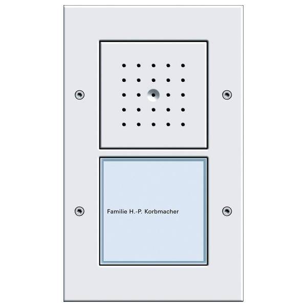 Türsprechanlage und Namensschild mit der Aufschrift 'Familie H.-P. Korbmacher' auf einem weißen Panel mit Schrauben an den Ecken.