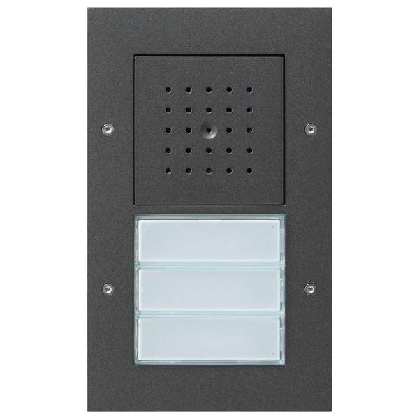 Ein rechteckiger Türsprechapparat mit einem Lautsprechergitter oben und drei beleuchteten Namenschildfächern darunter, eingesetzt in einem dunklen Rahmen.