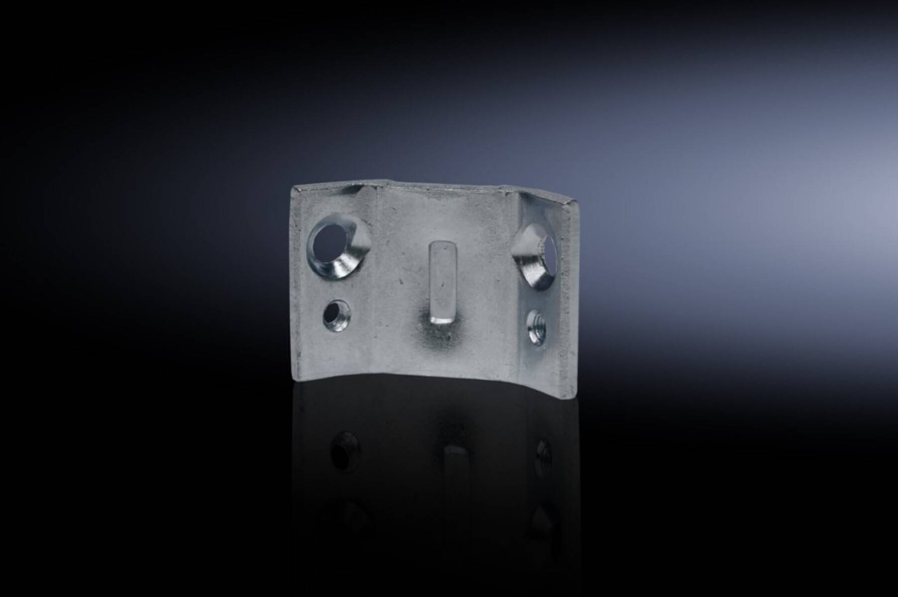 Nahaufnahme eines Metallsteckers oder einer Befestigungsklammer mit Schraubenlöchern auf einer dunklen reflektierenden Oberfläche, beleuchtet vor schwarzem Hintergrund.
