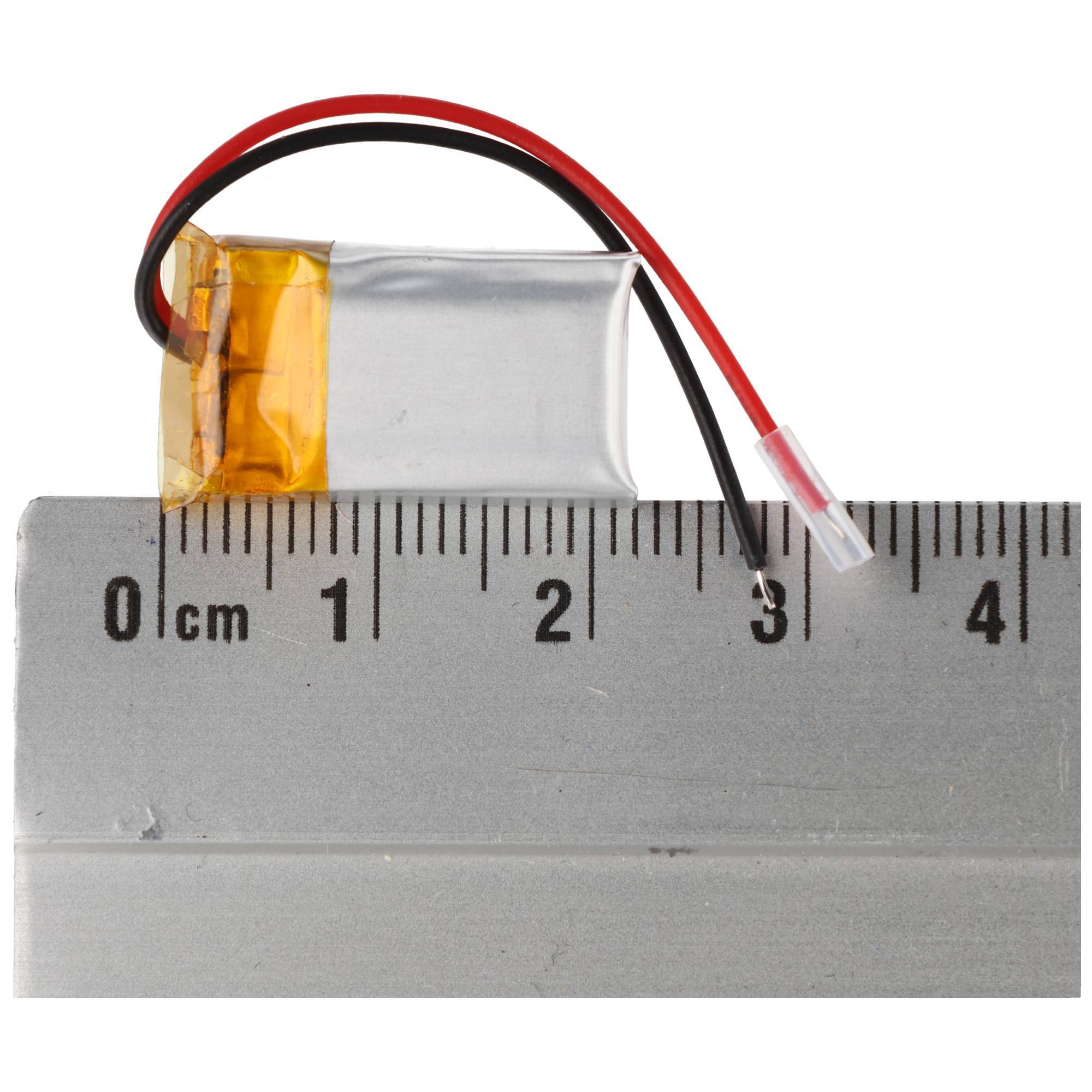 Kleine Lithium-Polymer-Batterie mit roten und schwarzen Drähten, die auf einem Lineal ruht und ihre kompakte Größe zeigt.