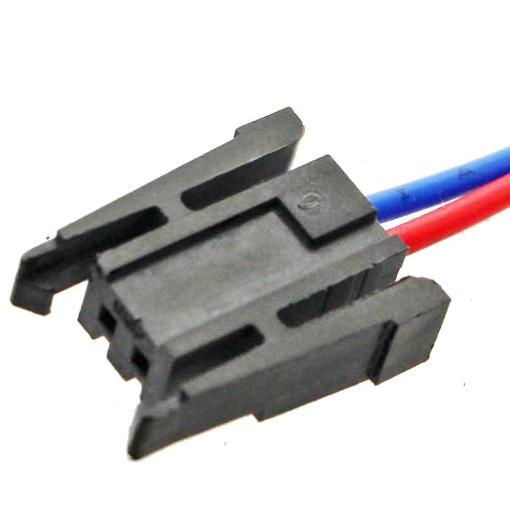 Nahaufnahme eines schwarzen zweipoligen Elektrosteckers mit angebrachten roten und blauen Drähten auf weißem Hintergrund.