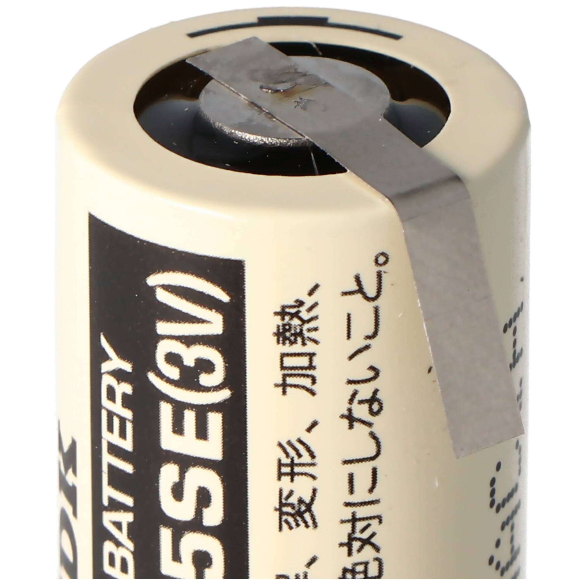 Nahaufnahme einer 3V-Batterie mit einem Metallstreifen, der über die oberen Anschlüsse geklebt ist, mit japanischem Warntext auf dem Etikett.