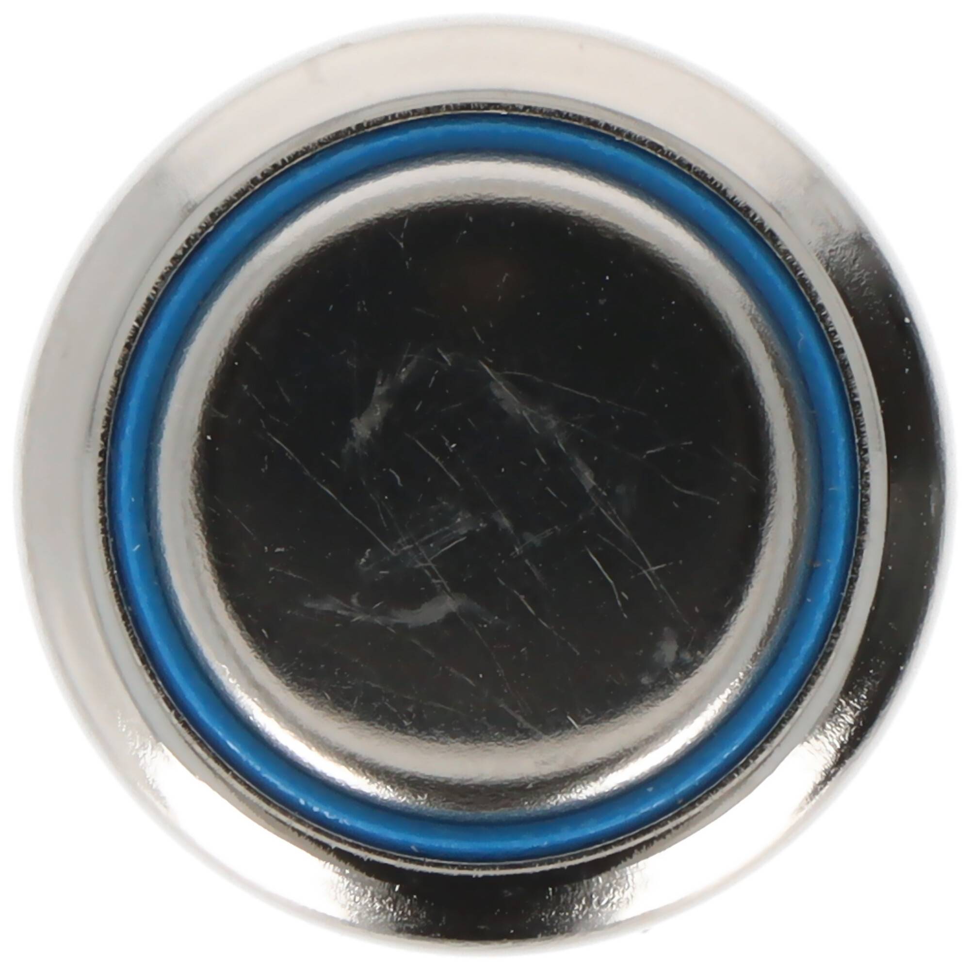 Nahaufnahme einer runden Metallkappe oder eines Deckels mit schwarzer Mitte und blauem Gummirinng, dargestellt auf weißem Hintergrund.