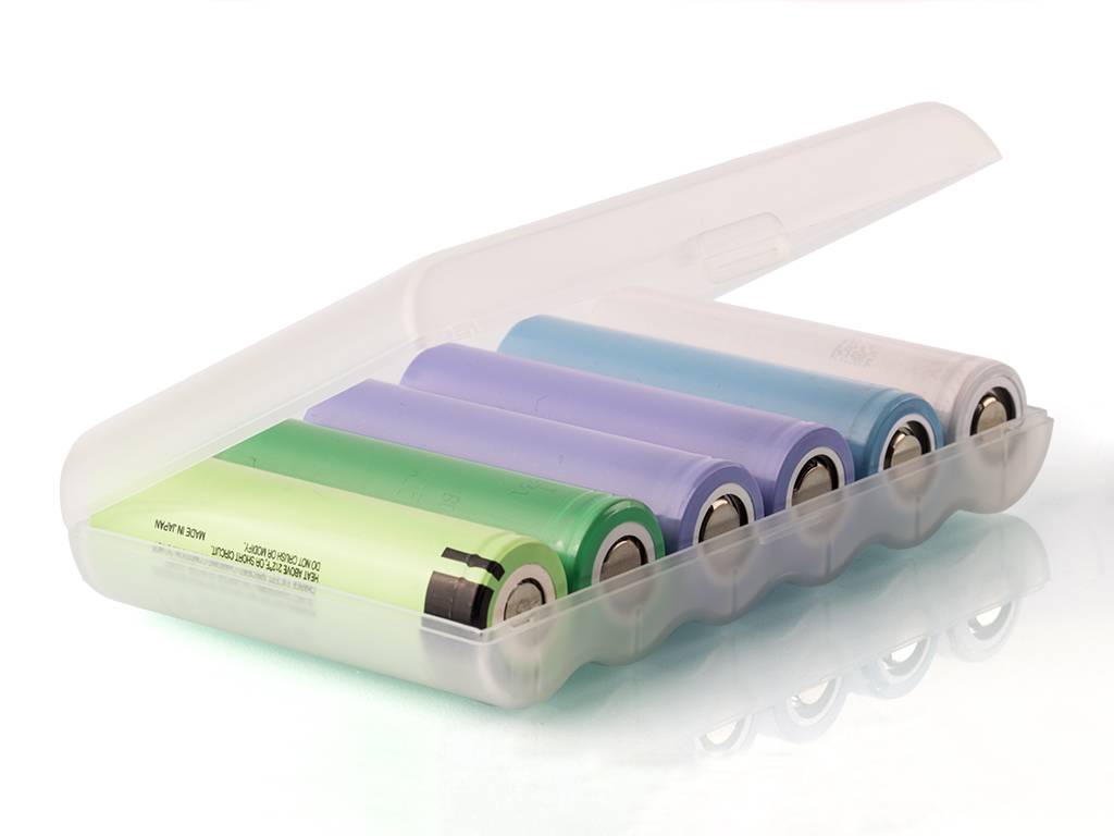 Eine durchscheinende Kunststoffbox mit fünf farbigen zylindrischen Batterien, geöffnet auf weißem Hintergrund dargestellt.