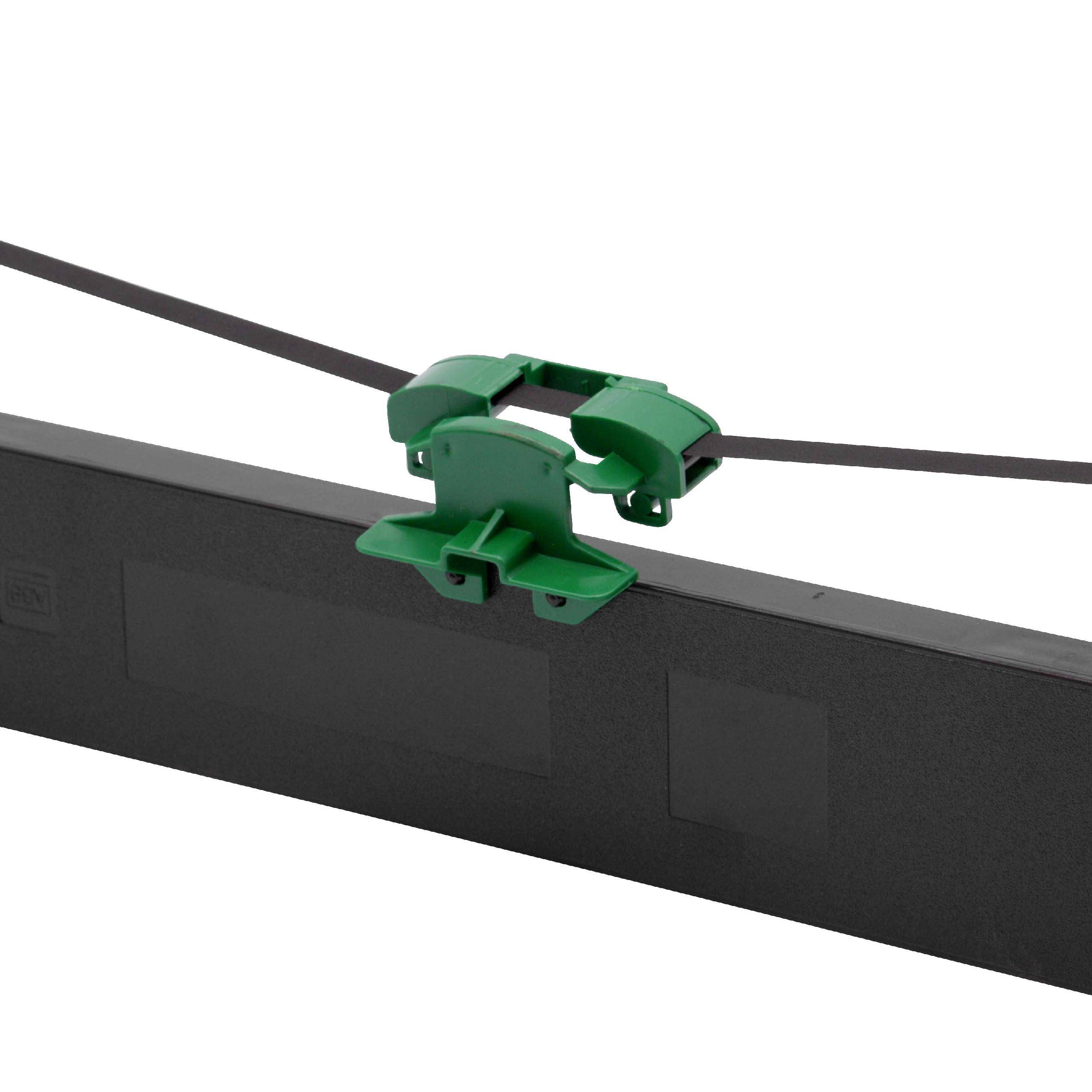 Ein grüner Plastikclip befestigt ein schwarzes Kabel über einem flachen, rechteckigen schwarzen Objekt, möglicherweise ein elektronisches Gerät oder eine Komponente.