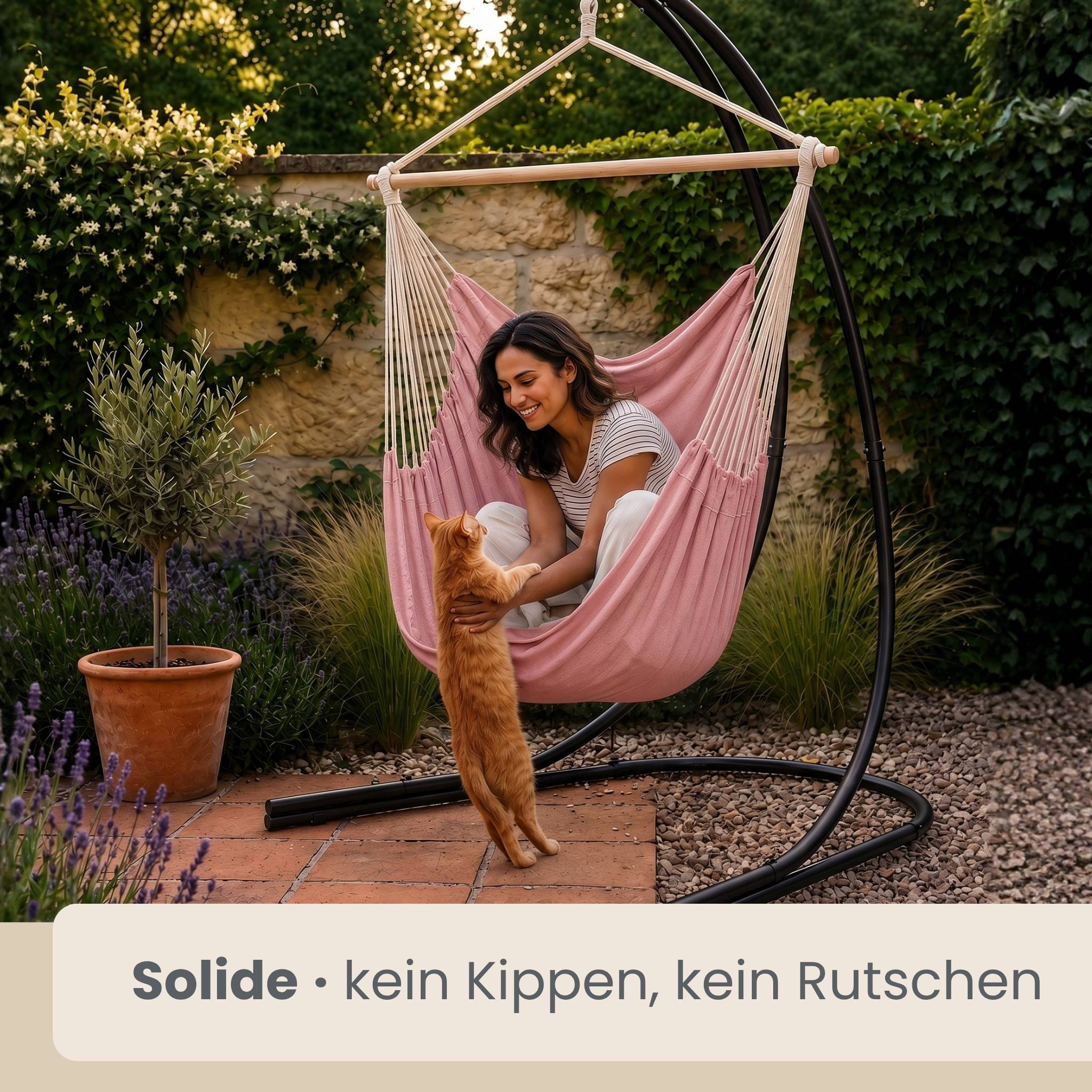 Frau, die sich in einem rosa hängenden Stuhl in einem Garten entspannt, während sie eine stehende orange Katze streichelt; Der deutsche Text besagt „Solide • kein Kippen, kein Rutschen