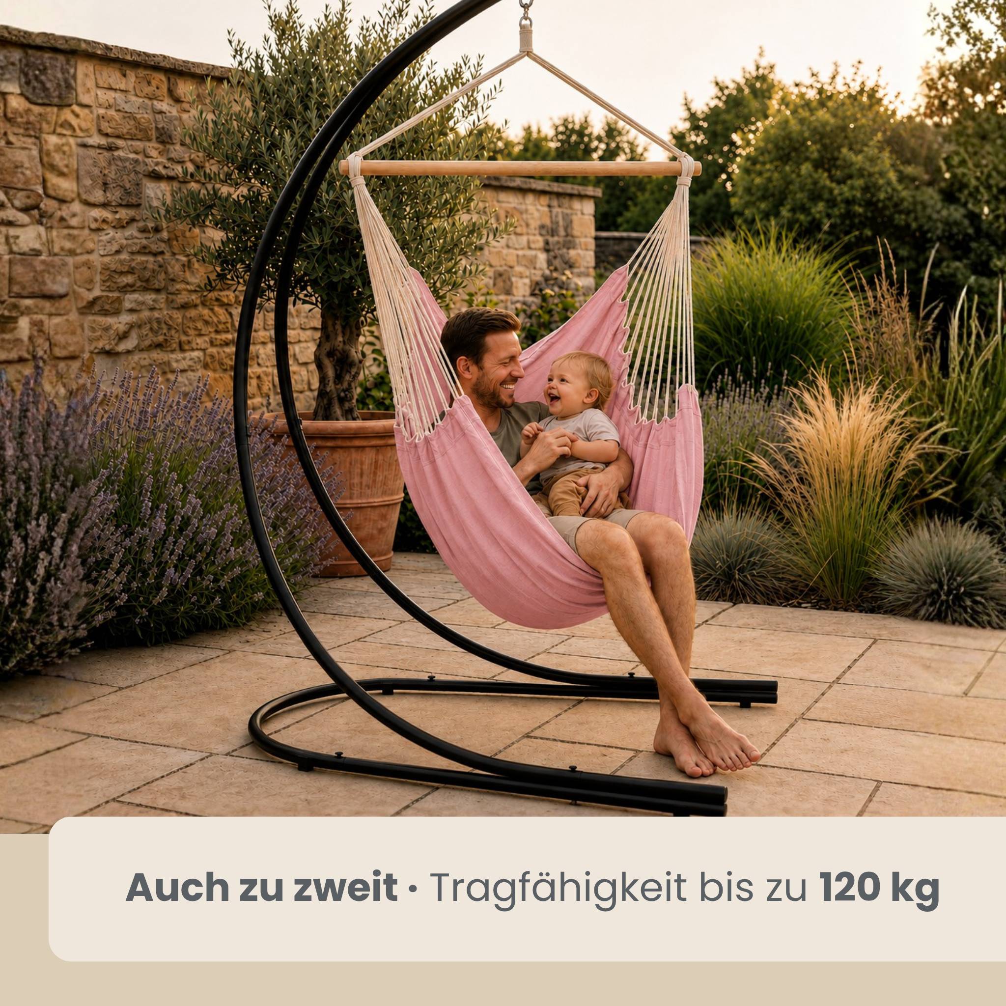 Mann und Baby sitzen zusammen in einem rosa hängenden Hängesessel im Freien; Text sagt „Auch zu zweit: Tragfähigkeit bis zu 120 kg