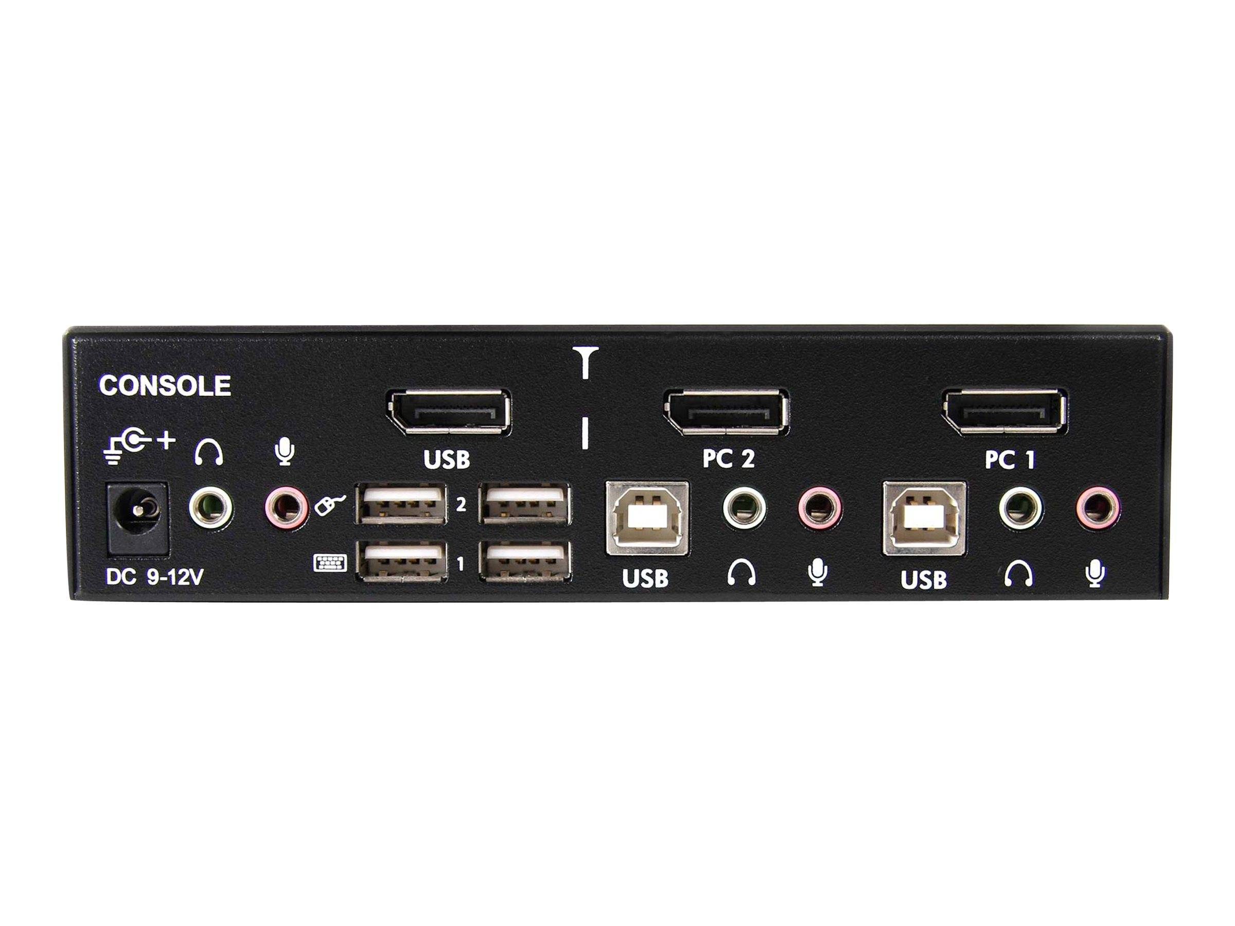 Frontplatte eines schwarzen KVM-ähnlichen Konsolenschalters mit gekennzeichneten Anschlüssen: DC 9-12V Stromversorgung, USB, PC 2 und PC 1, sowie Audio- und Mikrofoneingänge.