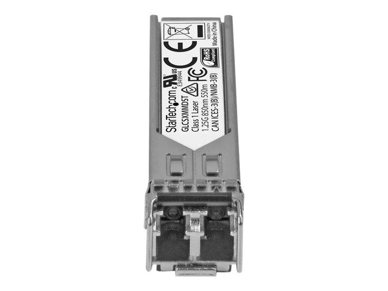 Ein Silber-Faseroptik-Transceiver-Modul mit einem Etikett, das CE- und Sicherheitsmarkierungen zeigt, fotografiert auf weißem Hintergrund.
