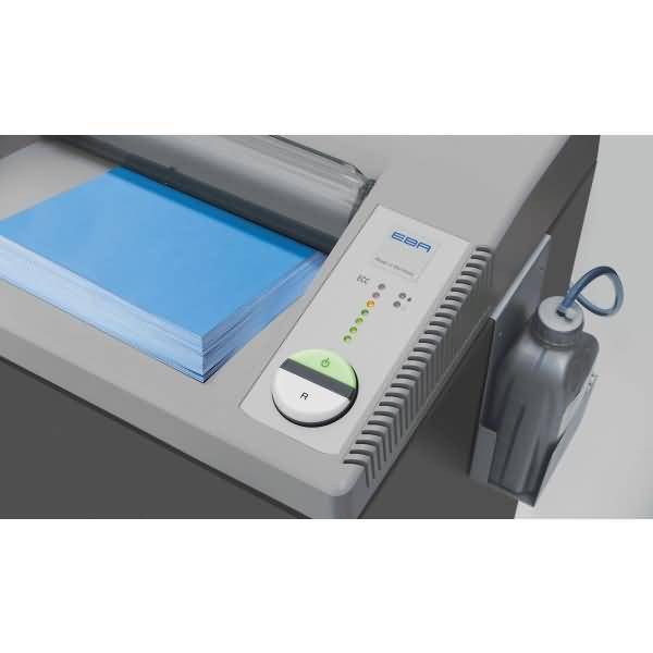 Nahaufnahme einer PapierBindemaschine, die einen blauen Stapel von Blättern zuführt, mit sichtbaren Steuertasten und einem Stromkabel auf der Seite.