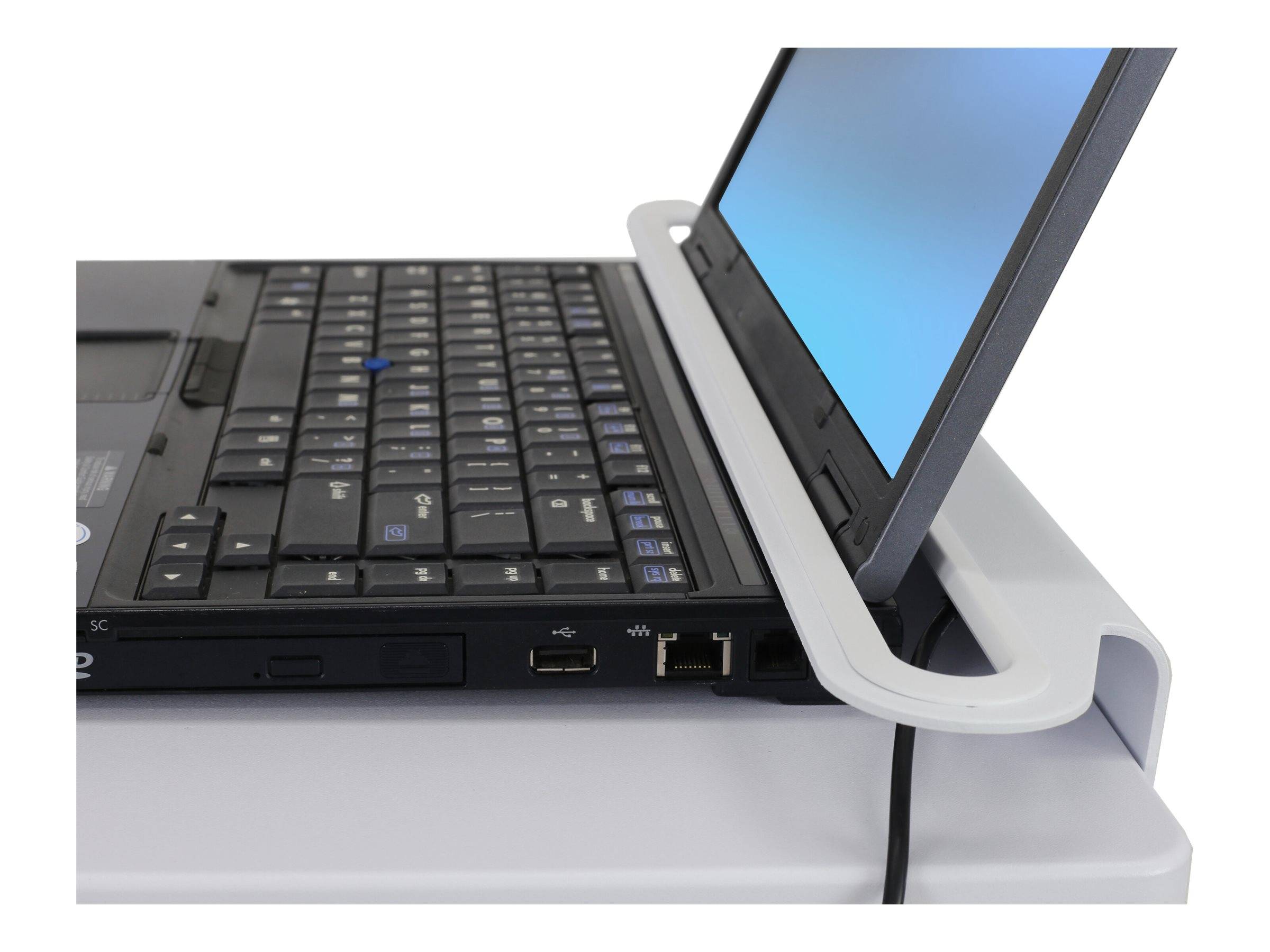 Ein Laptop in einer weißen Dockingstation mit geöffnetem, geneigtem Bildschirm, das Tastatur, Anschlüsse und Ladekabel zeigend.