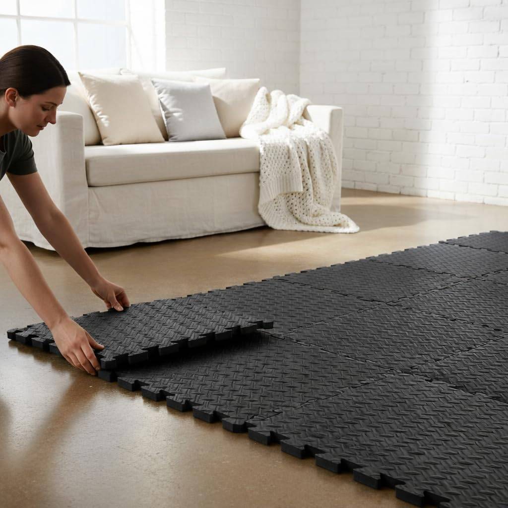 Frau montiert schwarze ineinandergreifende Schaumstoff-Bodenfliesen in einem Wohnzimmer neben einem weißen Sofa.