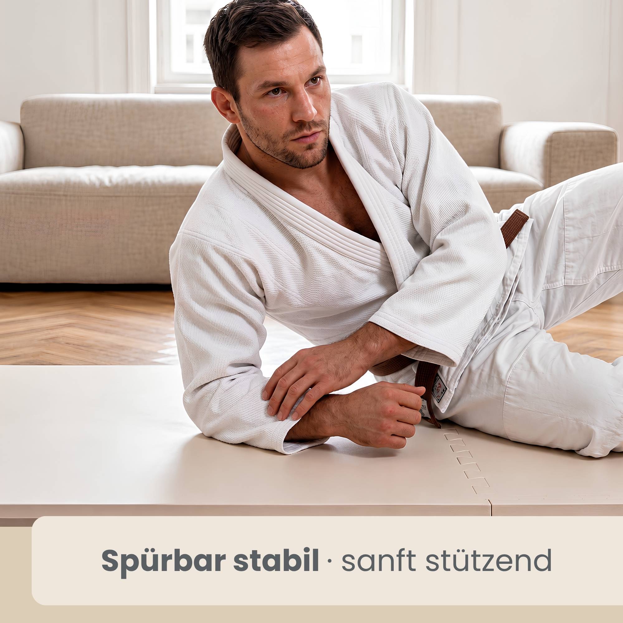Mann in weißem Martial-Arts-Anzug liegt auf einer Matte in einem hellen Raum; der Text lautet „spürbar stabil · sanft stützend
