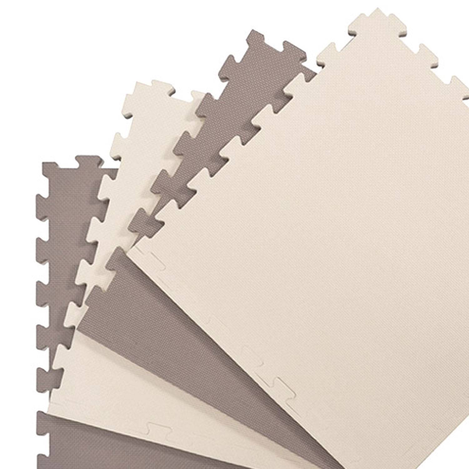 Stapelbare, verzahnte Schaumstoff-Puzzlematten in Beige und Grau, teilweise in einer fächerartigen Anordnung überlappt dargestellt.